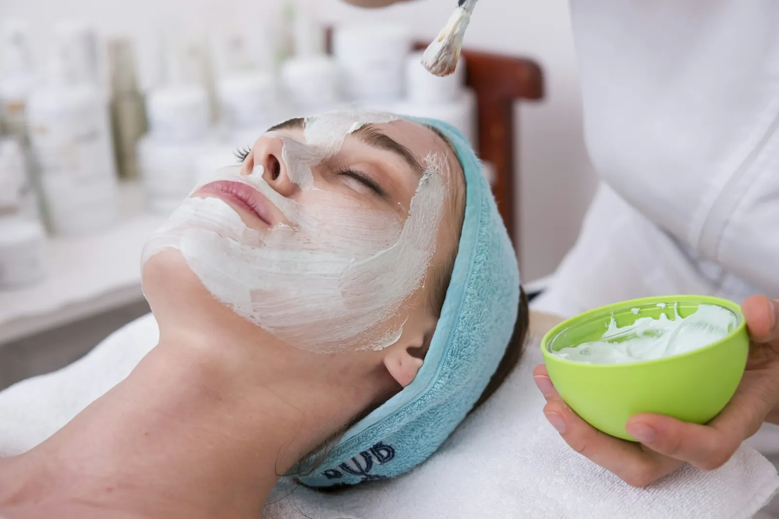 A client with a soothing face mask during a facial